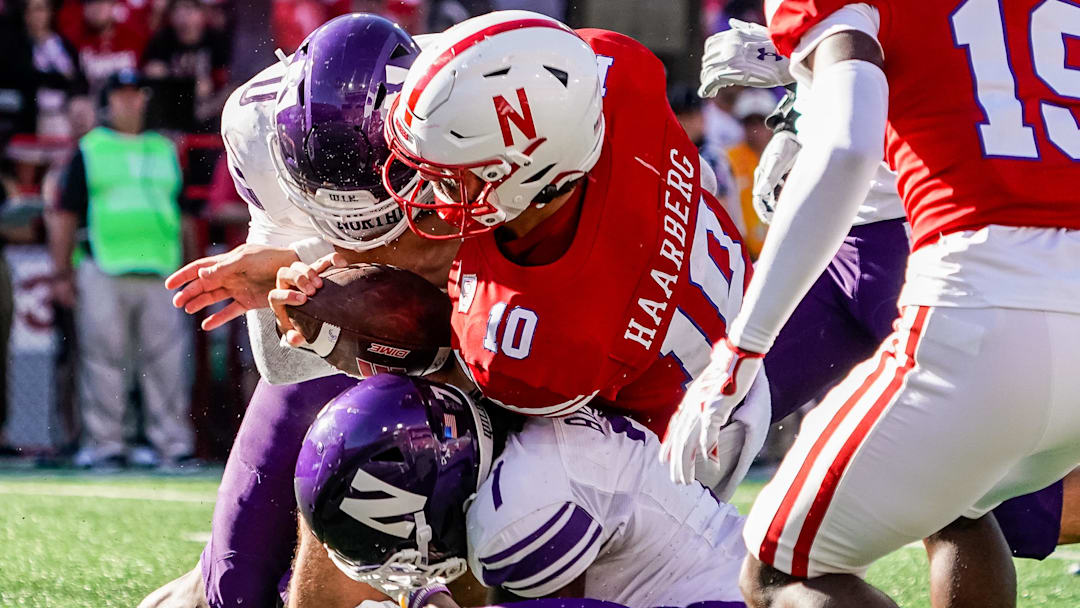 Nebraska Cornhuskers quarterback Heinrich Haarberg is stopped by Northwestern Wildcats defensive back Coco Azema and defensive back Ore Adeyi.