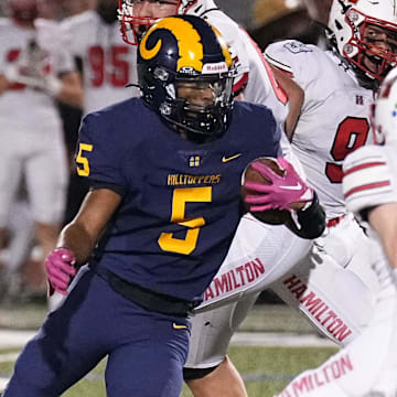 Marquette running back Tommy Novotny (5) weaves through the Sussex defenders during a Greater Metro Conference game at Hart Park on Friday, Oct.11, 2024.