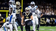 Sep 8, 2024; New Orleans, Louisiana, USA;  New Orleans Saints quarterback Taysom Hill (7) makes a first down against Carolina Panthers safety Nick Scott (21) during the first half at Caesars Superdome. Mandatory Credit: Stephen Lew-Imagn Images