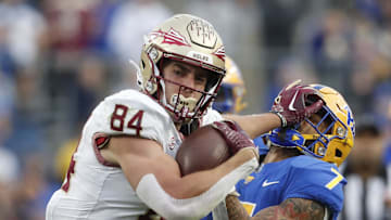 Nov 4, 2023; Pittsburgh, Pennsylvania, USA;  Florida State Seminoles tight end Kyle Morlock (84) stiff arms Pittsburgh Panthers defensive back Javon McIntyre (7) after a catch during the second quarter at Acrisure Stadium. Mandatory Credit: Charles LeClaire-Imagn Images