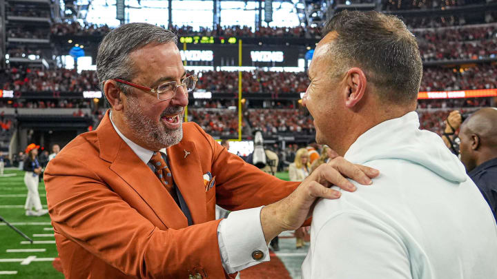 University of Texas at Austin athletic director Chris Del Conte celebrates with head coach Steve Sarkisian.