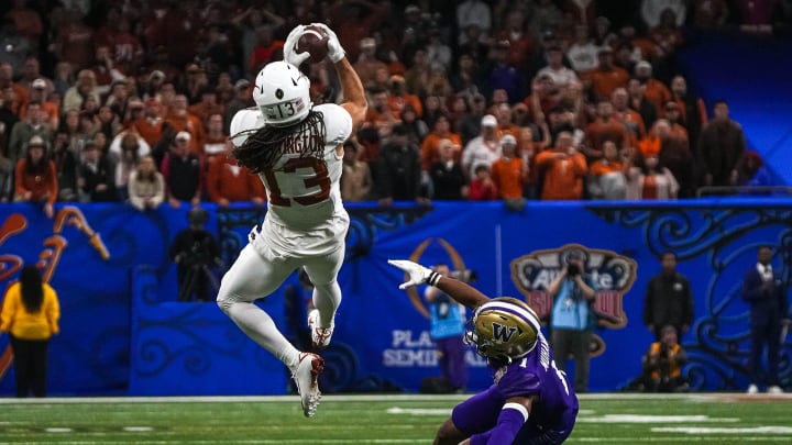 Texas Longhorns wide receiver Jordan Whittington (13) makes a catch over Washington cornerback Jabbar Muhammad (1) during the Sugar Bowl College Football Playoff  semifinals game at the Caesars Superdome on Monday, Jan. 1, 2024 in New Orleans, Louisiana.