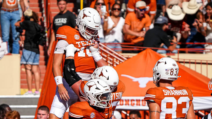 Texas Longhorns offensive lineman Conner Robertson (62) lifts quarterback Arch Manning (16) to celebrate touchdown Saturday's win over Colorado State.