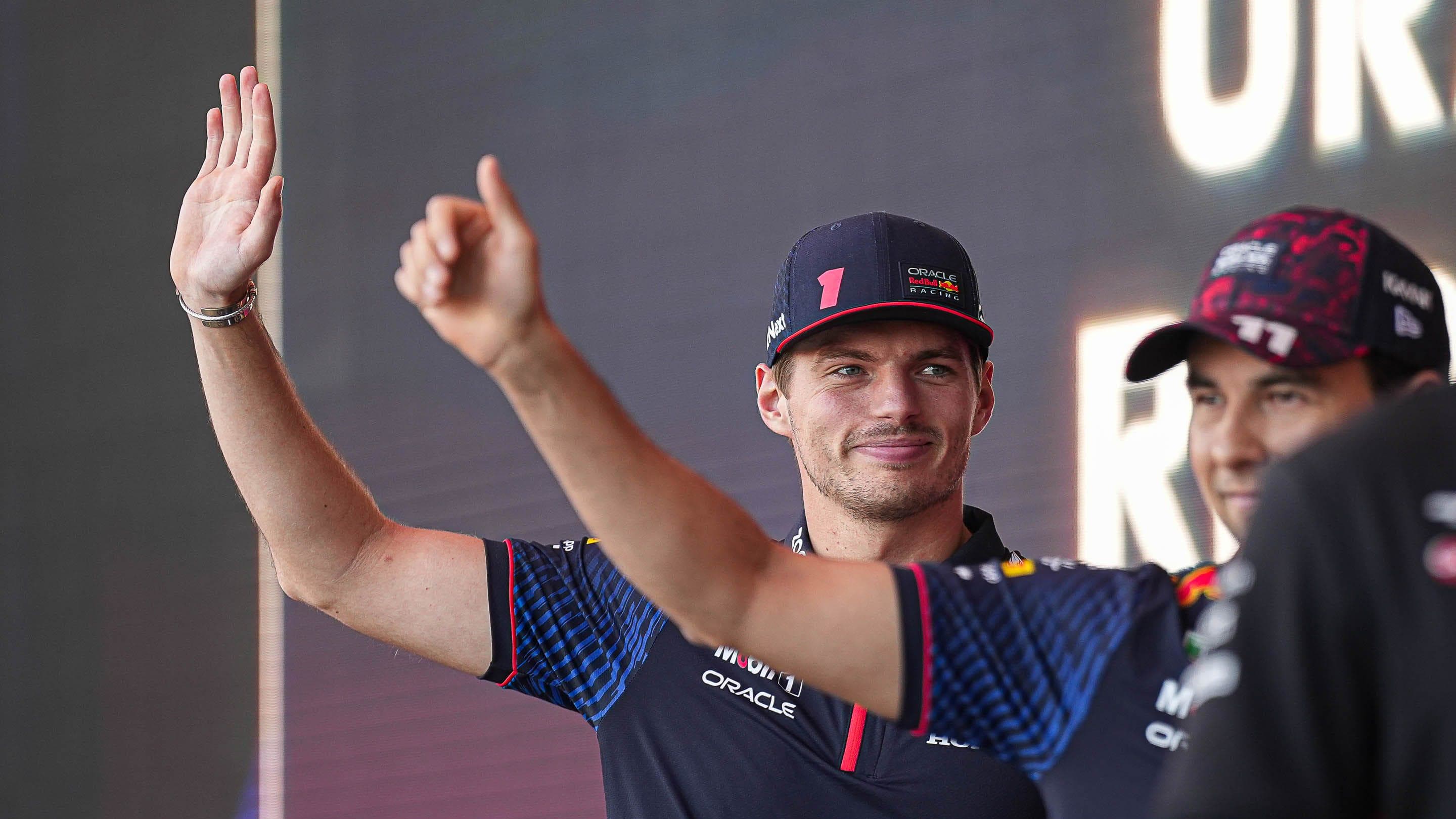 Oracle Red Bull Racing driver Max Verstappen waves to the crowd as he leaves the stage during driver