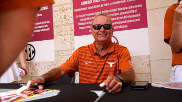 Texas Longhorns women's basketball coach Vic Schaefer signs posters for fans during the SEC Celebration at the University of Texas at Austin on Sunday, June 30, 2024.