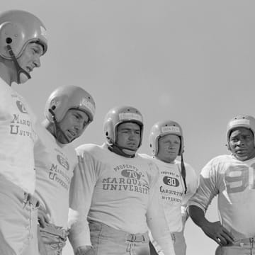 Green Bay Packers quarterback Babe Parilli talks with fellow rookies Bobby Dillon, Bill Reichardt, Chuck Boerio, Billy Howton and Tom Johnson during a training camp practice in 1952. 