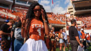 Loreal Sarkisian, wife of Texas head coach Steve Sarkisian, holds up the sign of the horns in the endzone before the game against Alabama at Royal Memorial Stadium.