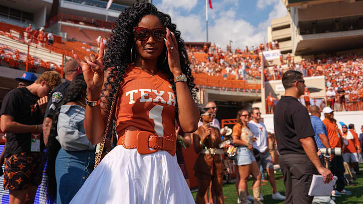 Loreal Sarkisian, wife of Texas head coach Steve Sarkisian, holds up the sign of the horns in the endzone before the game.
