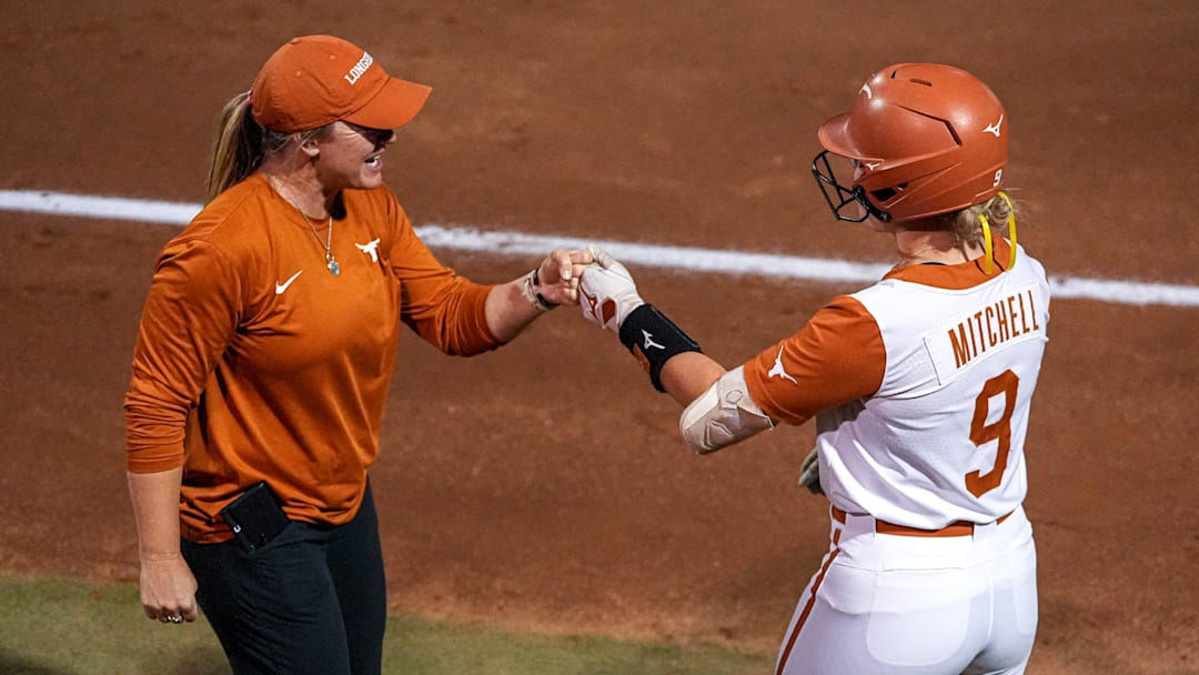 Texas Longhorns infielder Joley Mitchell (9) celebrates a single hit with assistant coach Kristen Zaleski during the game against Tennessee at Red & Charline McCombs Field on Friday, April 11, 2025 in Austin.