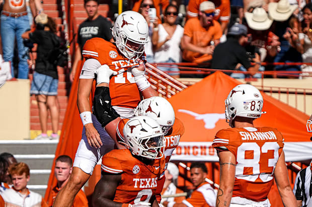Texas Longhorns offensive lineman Conner Robertson lifts quarterback Arch Manning to celebrate a rushing touchdown