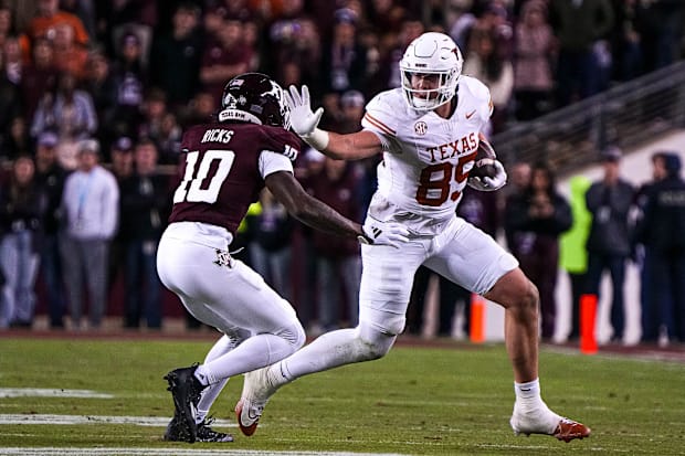 Longhorns tight end Gunnar Helm attempts to break a tackle by Aggies defensive back Dezz Ricks.