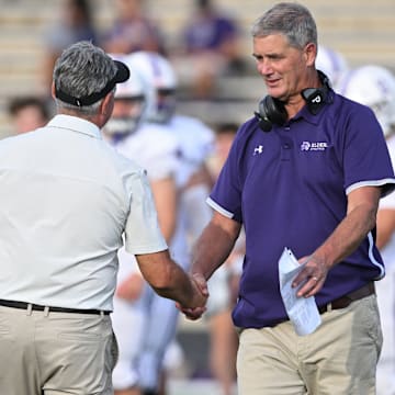 St. Edward head coach Tom Lombardo (left) shakes hands with Elder coach Doug Ramsey after the teams played on September 10, 2022.