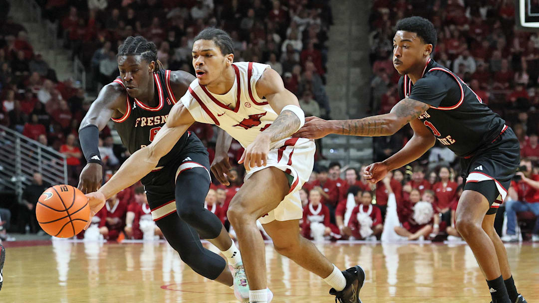Dec 6, 2025; North Little Rock, Arkansas, USA; Arkansas Razorbacks guard Darius Acuff Jr (5) reaches for the ball between Fresno State Bulldogs guards DJ Stickman (6) and Zaon Collins (10) during the second half at Simmons Bank Arena. Arkansas won 82-58. Mandatory Credit: Nelson Chenault-Imagn Images Dec 6, 2025; North Little Rock, Arkansas, USA; Arkansas Razorbacks guard Darius Acuff Jr (5) reaches for the ball between Fresno State Bulldogs guards DJ Stickman (6) and Zaon Collins (10) during the second half at Simmons Bank Arena. Arkansas won 82-58. Mandatory Credit: Nelson Chenault-Imagn Images