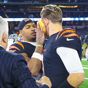 Dec 9, 2024; Arlington, Texas, USA;  Cincinnati Bengals wide receiver Ja'Marr Chase (1) smashes a donut on the face of Cincinnati Bengals quarterback Joe Burrow (9) after the game against the Dallas Cowboys at AT&T Stadium. Mandatory Credit: Kevin Jairaj-Imagn Images