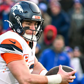 Jan 12, 2025; Orchard Park, New York, USA; Denver Broncos quarterback Bo Nix (10) runs out of the pocket in the fourth quarter of an AFC wild card game against the Buffalo Bills at Highmark Stadium. Mandatory Credit: Mark Konezny-Imagn Images