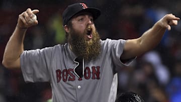 A Boston Red Sox fan reacts after getting a ball during the sixth inning in a game against the Red Sox and Seattle Mariners at Fenway Park.