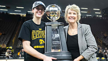 Iowa guard Caitlin Clark, left, poses for a photo with Iowa head coach Lisa Bluder as they hold their Big Ten regular season championship trophy after a NCAA Big Ten Conference women's basketball game against Michigan, Sunday, Feb. 27, 2022, at Carver-Hawkeye Arena in Iowa City, Iowa.