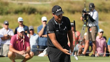Sep 22, 2024; Carrolton, Texas, USA; Patrick Reed of the 4Aces GC flips his putter in the air after missing a putt on the 18th green during the LIV Golf Dallas Team Championship Finals at Maridoe Golf Club. Mandatory Credit: Jim Cowsert-Imagn Images