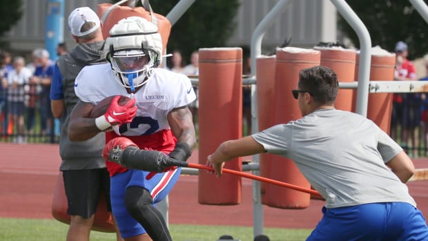 Bills running back Ray Davis secures the ball as he runs an obstacle course.