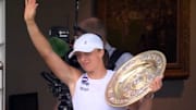 Iga Swiatek waves to the Wimbledon crowd after winning the 2025 title.