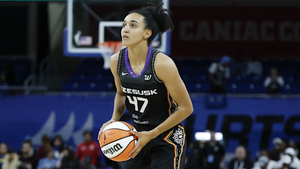 Connecticut Sun guard Leila Lacan lines up a shot wearing a black uniform.