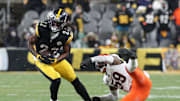 Jan 4, 2025; Pittsburgh, Pennsylvania, USA;  Pittsburgh Steelers running back Najee Harris (22) sheds a tackle attempt by Cincinnati Bengals linebacker Akeem Davis-Gaither (59) after catching a pass during the fourth quarter at Acrisure Stadium. Mandatory Credit: Charles LeClaire-Imagn Images