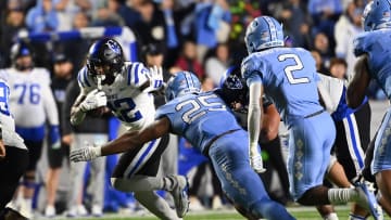 Nov 11, 2023; Chapel Hill, North Carolina, USA; Duke Blue Devils running back Jaylen Coleman (22) runs as North Carolina Tar Heels linebacker Kaimon Rucker (25) and defensive back Don Chapman (2) defend in the fourth quarter at Kenan Memorial Stadium. Mandatory Credit: Bob Donnan-USA TODAY Sports