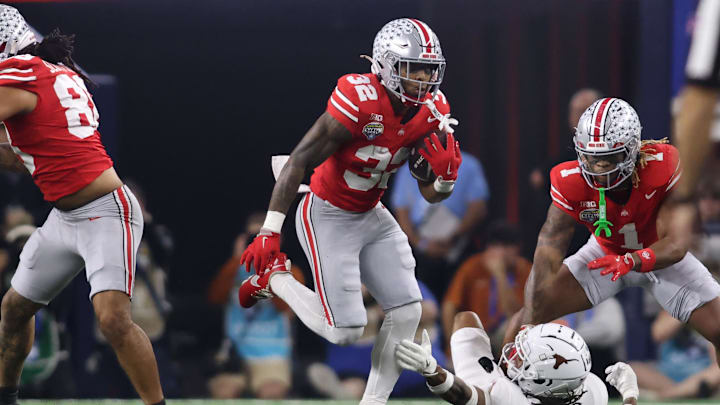 Jan 10, 2025; Arlington, Texas, USA; Ohio State Buckeyes running back TreVeyon Henderson (32) runs against Texas Longhorns defensive back Jaylon Guilbeau (3) during the first quarter of the College Football Playoff semifinal in the Cotton Bowl at AT&T Stadium. Mandatory Credit: Tim Heitman-Imagn Images Jan 10, 2025; Arlington, Texas, USA; Ohio State Buckeyes running back TreVeyon Henderson (32) runs against Texas Longhorns defensive back Jaylon Guilbeau (3) during the first quarter of the College Football Playoff semifinal in the Cotton Bowl at AT&T Stadium. Mandatory Credit: Tim Heitman-Imagn Images