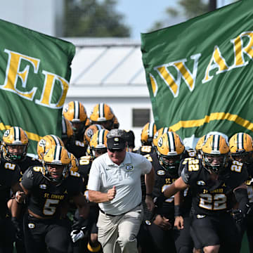 St. Edward football head coach Tom Lombardo leads the Eagles onto the field before a game against Elder on September 10, 2022. 