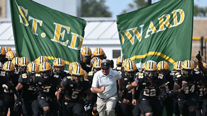 St. Edward football head coach Tom Lombardo leads the Eagles onto the field before a game against Elder on September 10, 2022. 