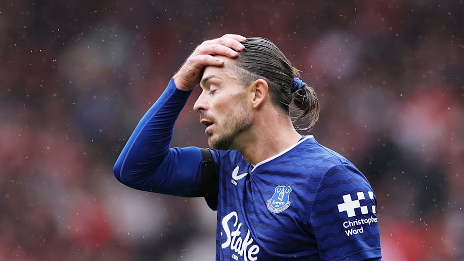 Jack Grealish with his hand on his head.