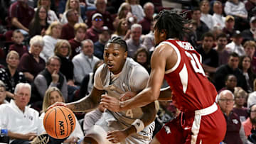Feb 15, 2025; College Station, Texas, USA; Texas A&M Aggies guard Wade Taylor IV (4) drives as Arkansas Razorbacks guard D.J. Wagner (21) defends during the first half at Reed Arena. Mandatory Credit: Maria Lysaker-Imagn Images 
