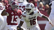 Oct 12, 2024; Tuscaloosa, Alabama, USA;  South Carolina Gamecocks quarterback LaNorris Sellers (16) peels away from pressure by Alabama Crimson Tide defensive back Malachi Moore (13) at Bryant-Denny Stadium. Alabama defeated South Carolina 27-25. Mandatory Credit: Gary Cosby Jr.-Imagn Images
