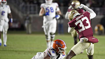 Nov 30, 2024; Tallahassee, Florida, USA; Florida State Seminoles defensive back Edwin Joseph (33) strips the ball from Florida Gators tight end Tony Livingston (86) during the first half at Doak S. Campbell Stadium. Mandatory Credit: Melina Myers-Imagn Images