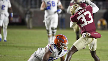 Nov 30, 2024; Tallahassee, Florida, USA; Florida State Seminoles defensive back Edwin Joseph (33) strips the ball from Florida Gators tight end Tony Livingston (86) during the first half at Doak S. Campbell Stadium. Mandatory Credit: Melina Myers-Imagn Images
