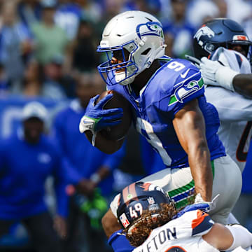 Sep 8, 2024; Seattle, Washington, USA; Seattle Seahawks running back Kenneth Walker III (9) breaks a tackle attempt by Denver Broncos linebacker Alex Singleton (49) to rush for a touchdown during the third quarter at Lumen Field. Mandatory Credit: Joe Nicholson-Imagn Images