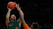 Feb 11, 2025; Coral Gables, Florida, USA; Miami Hurricanes guard Matthew Cleveland (0) shoots the basketball over Syracuse Orange guard Lucas Taylor (3) during the second half at Watsco Center. Mandatory Credit: Sam Navarro-Imagn Images