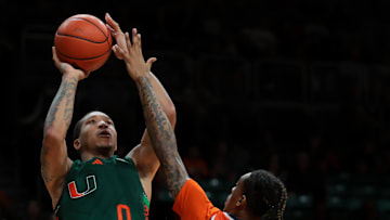 Feb 11, 2025; Coral Gables, Florida, USA; Miami Hurricanes guard Matthew Cleveland (0) shoots the basketball over Syracuse Orange guard Lucas Taylor (3) during the second half at Watsco Center. Mandatory Credit: Sam Navarro-Imagn Images