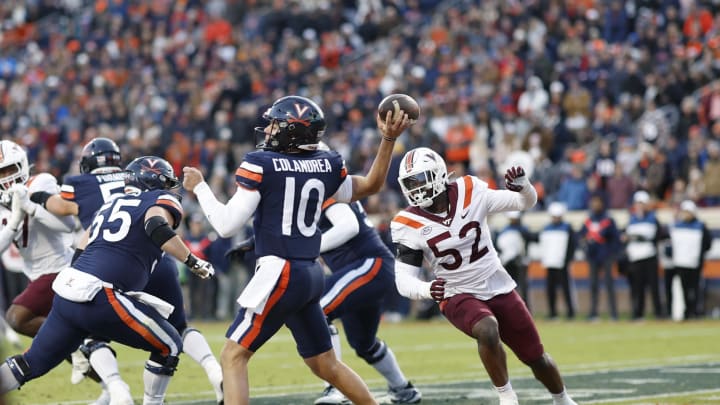 Nov 25, 2023; Charlottesville, Virginia, USA; Virginia Cavaliers quarterback Anthony Colandrea (10) passes the ball from his own end zone as Virginia Tech Hokies defensive lineman Antwaun Powell-Ryland (52) chases during the second quarter at Scott Stadium. Mandatory Credit: Geoff Burke-USA TODAY Sports