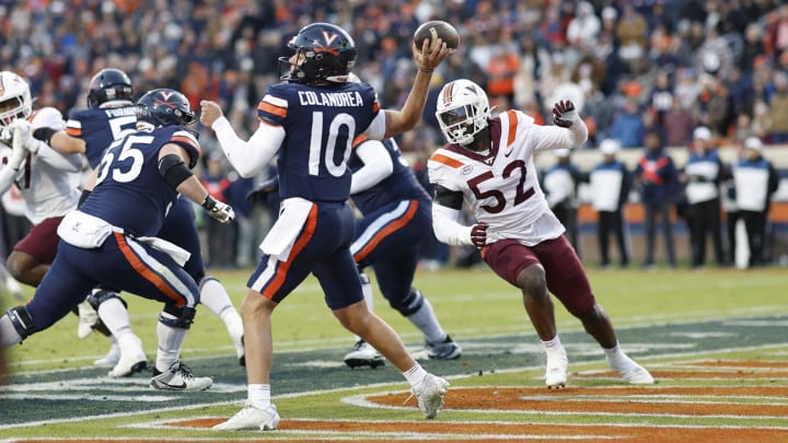 Nov 25, 2023; Charlottesville, Virginia, USA; Virginia Cavaliers quarterback Anthony Colandrea (10) passes the ball from his own end zone as Virginia Tech Hokies defensive lineman Antwaun Powell-Ryland (52) chases during the second quarter at Scott Stadium. Mandatory Credit: Geoff Burke-USA TODAY Sports