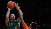 Feb 11, 2025; Coral Gables, Florida, USA; Miami Hurricanes guard Matthew Cleveland (0) shoots the basketball over Syracuse Orange guard Lucas Taylor (3) during the second half at Watsco Center. Mandatory Credit: Sam Navarro-Imagn Images