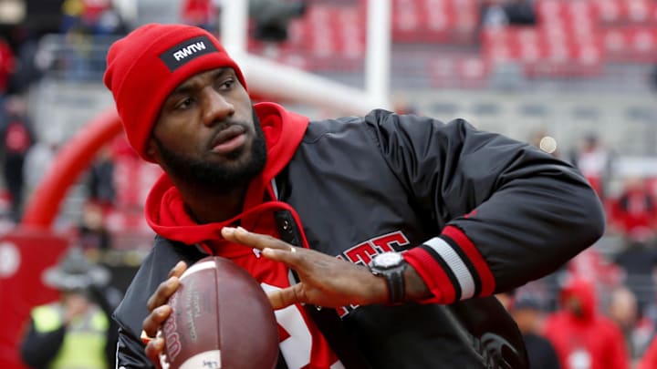 NBA star LeBron James throws a football around at an Ohio State game. NBA star LeBron James throws a football around at an Ohio State game.