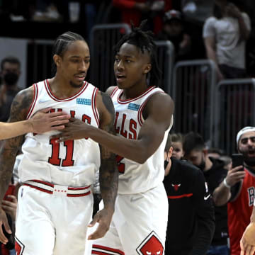 Feb 24, 2022; Chicago, Illinois, USA;  Chicago Bulls forward DeMar DeRozan (11) celebrates with Chicago Bulls guard Zach LaVine (8) and Chicago Bulls guard Ayo Dosunmu (12) after he scores against the Atlanta Hawks at the end of the second half at the United Center.