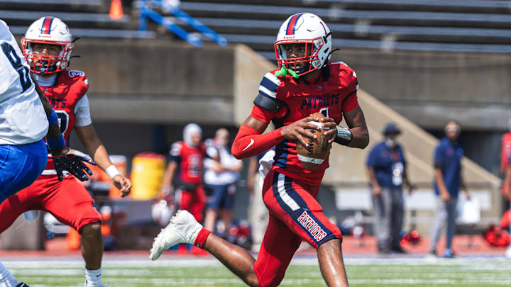 Denbigh High School Quarterback rolls out the pocket.