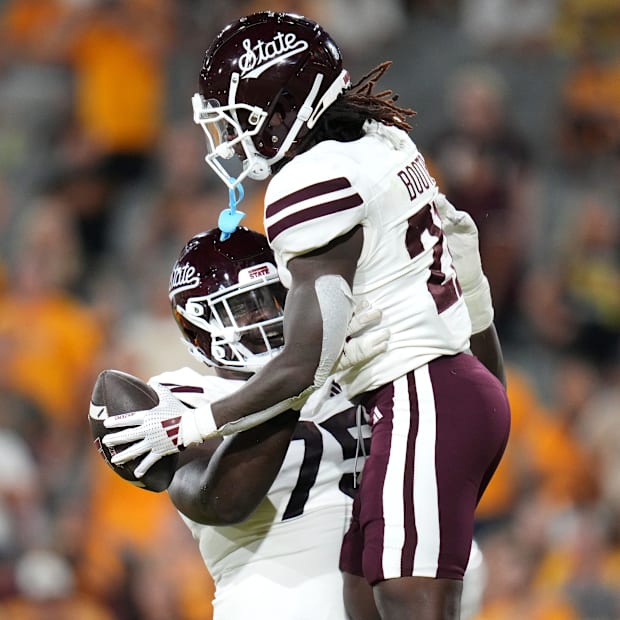 Mississippi State Bulldogs offensive lineman Jacoby Jackson lifts up teammate Davon Booth after his rushing touchdown.