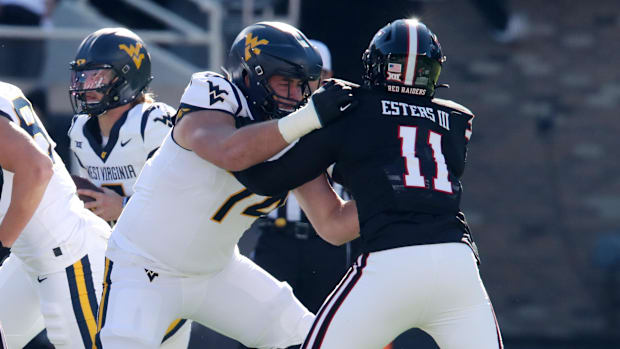 Offensive lineman Wyatt Milum (white jersey) blocks a pass-rusher off the edge.