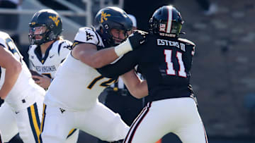 Nov 30, 2024; Lubbock, Texas, USA;  West Virginia Mountaineers offensive lineman Wyatt Milum (74) blocks Texas Tech Red Raiders defensive back Charles Esters III (11) in the first half at Jones AT&T Stadium and Cody Campbell Field. Mandatory Credit: Michael C. Johnson-Imagn Images
