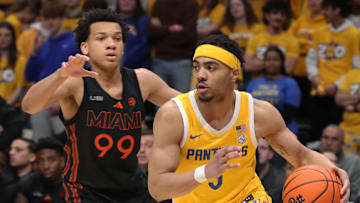 Feb 15, 2025; Pittsburgh, Pennsylvania, USA; Pittsburgh Panthers guard Ishmael Leggett (5) dribbles around Miami (Fl) Hurricanes guard Divine Ugochukwu (99) during the second half at the Petersen Events Center. Mandatory Credit: Charles LeClaire-Imagn Images