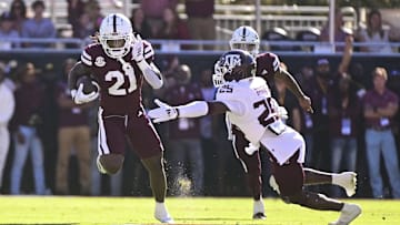 Oct 19, 2024; Starkville, Mississippi, USA; Mississippi State Bulldogs running back Davon Booth (21) runs the ball against Texas A&M Aggies defensive back Dalton Brooks (25) during the first quarter at Davis Wade Stadium at Scott Field. Mandatory Credit: Matt Bush-Imagn Images