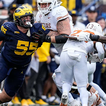 Michigan defensive lineman Mason Graham (55) and defensive end Derrick Moore (8) tackle Texas running back Jaydon Blue (23) during the second half at Michigan Stadium in Ann Arbor on Saturday, September 7, 2024.